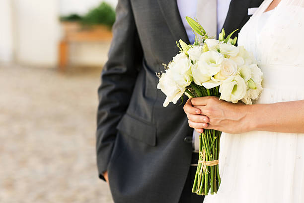 istock Bride Holding Bouquet Of Flowers While Standing With Groom 516778705