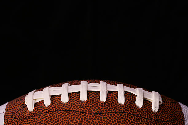 istock American Football. Ball over black 516778785