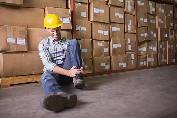istock Worker with sprained ankle on floor in warehouse 516782515