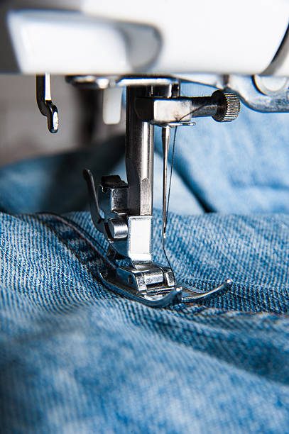 istock Part of sewing machine and jeans cloth 516787562