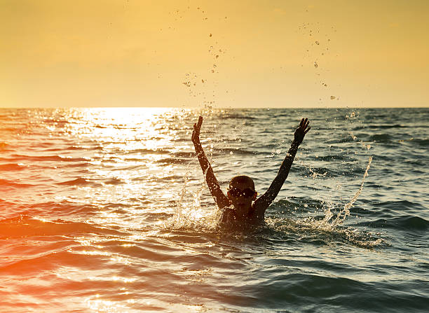 istock Silhouette of two boy jumping in sea 516794896