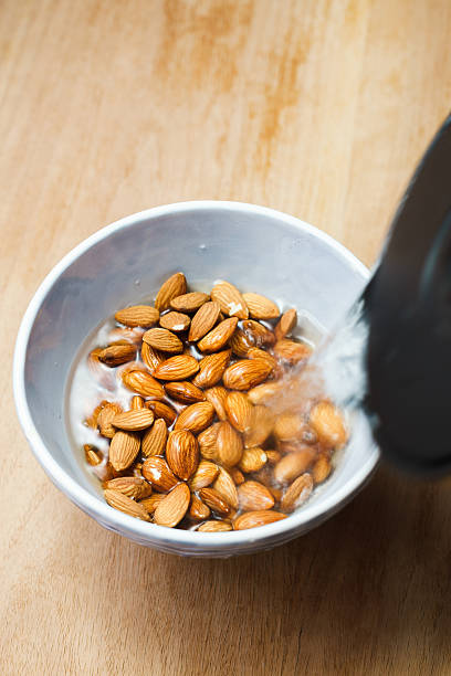 Blanching almonds with hot water Blanching almonds with hot water. Selective focus drenched stock pictures, royalty-free photos & images