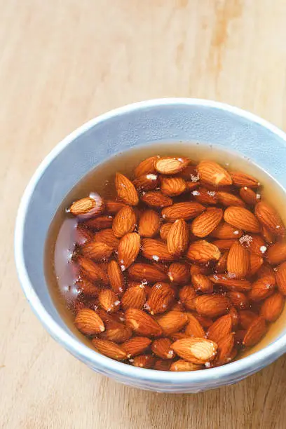 Soaking almonds in blue bowl. Selective focus