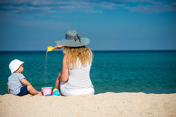 istock Young beautiful mother with her little boy on the beach 516797800