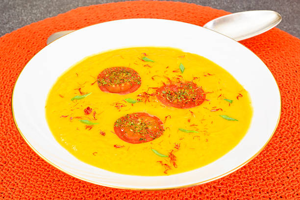 istock Pumpkin Soup with Carrot and Cherry Tomatoes, Saffron, Dried Her 516800200