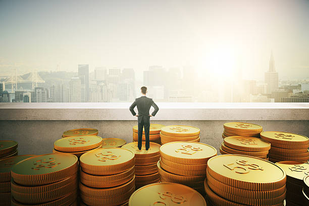 istock businessman standing on gold coins 516801108
