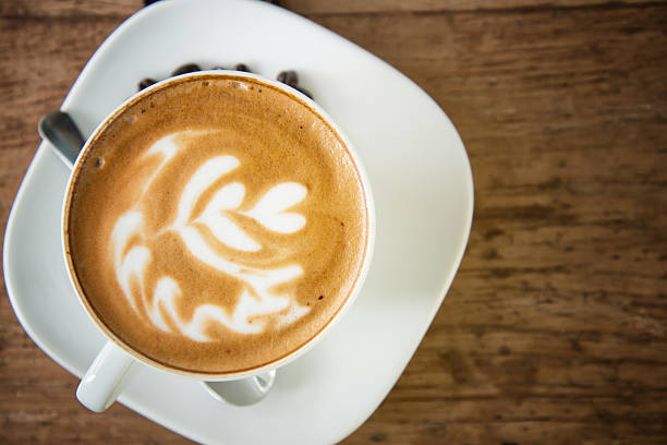 istock Hot latte in white cup on wood background 516809007