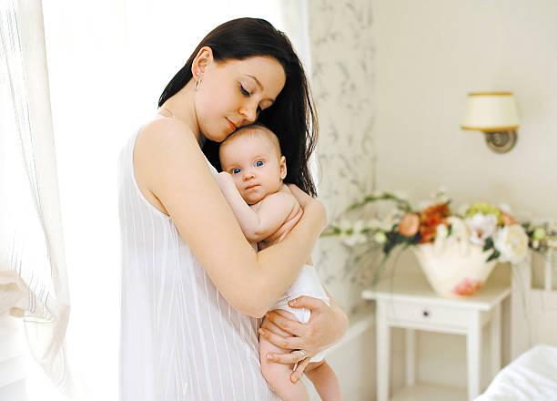 istock Happy mom gently hugs the baby 516811251