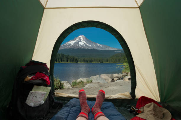 Image depicts interior of a tent with a view of Mount Hood from Trillium Lake, Oregon, USA.Tent interior shows a backpack with trail maps, sleeping bag and backpackers two stocking feet.http://www.garyalvis.com/images/pointsOfInterest.jpg