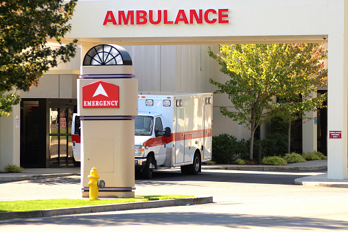 Ambulance sitting at the door of an emergency room at a hospital