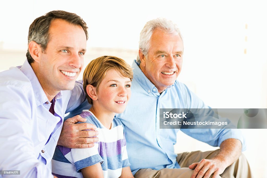 Three Generation Of Males Looking Away While Sitting At Home Happy three generation of males looking away while sitting at home. Horizontal shot. 10-11 Years Stock Photo