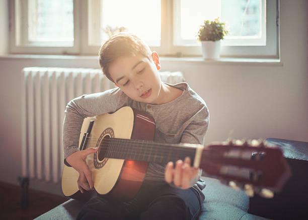 Boy playing guitar at home