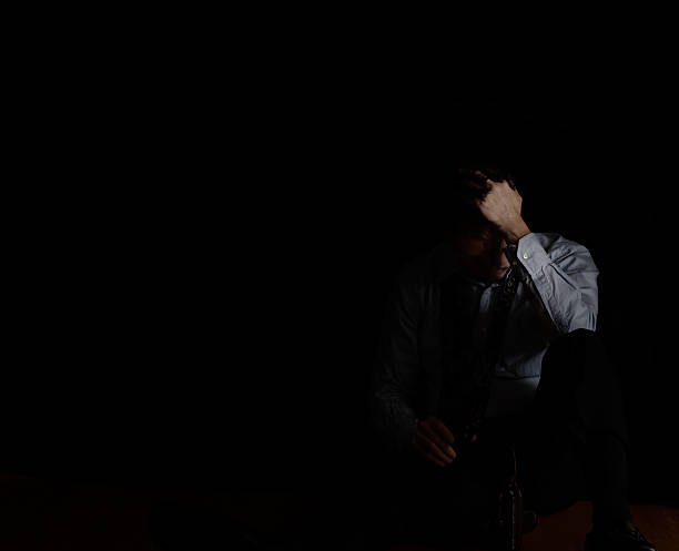 istock Sitting mature man holding head while holding beer 516815302