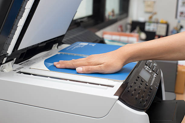 istock woman hands putting a paper into a copying device 516816538