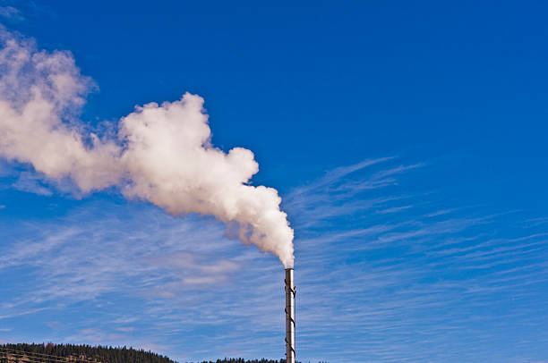istock Steam from tall chimney against dark blue sky 516817798