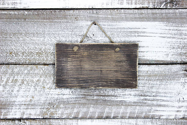 istock Blank wood sign hanging on rustic door 516818908