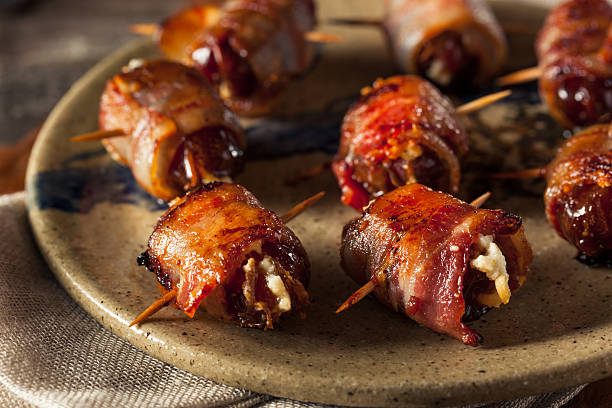 Homemade Bacon Wrapped Dates Homemade Bacon Wrapped Dates with Goat Cheese bacon wrapped stock pictures, royalty-free photos & images