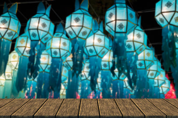 light of decorating paper lantern at Night in Yeepeng festival which is thailand tradition (blur background with wood table top for display or montage your product)