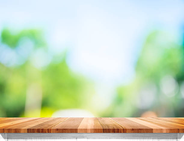 Empty brown wood table top with sun and blur tree