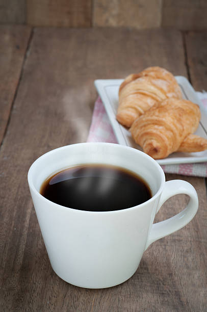 istock dining table with hot coffee cup and croissant. 516826544