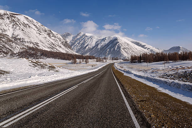 istock mountain road snow winter trees 516827146