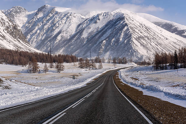 istock mountain road snow winter trees 516827290