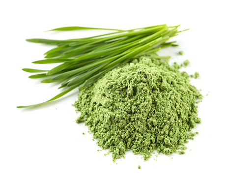 heap of green wheat powder isolated on white background, selective focus