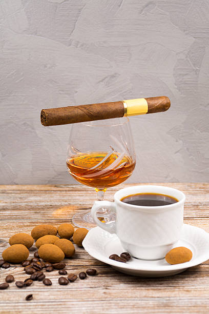 istock Cigar, brandy, cup coffee espresso with chocolate eggs and grape 516844266