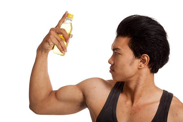 istock Muscular Asian man flexing biceps with electrolyte drink 516844814