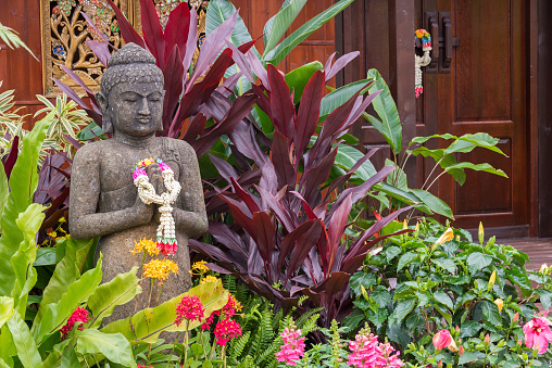 Stone buddha statue in flower garden