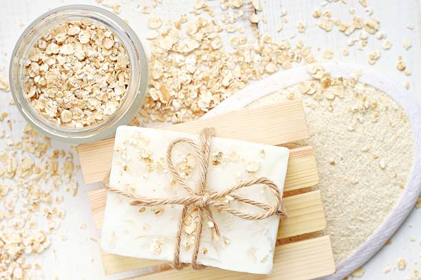 oats skin care treatment Rolled oats scattered, body scrubber, handmade soap bar. loofah photos stock pictures, royalty-free photos & images