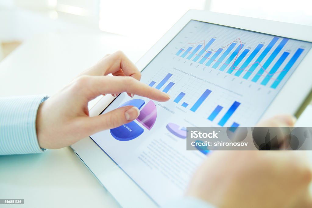 Hi-tech analysis Close-up image of an office worker using a touchpad to analyze statistical data Data Stock Photo