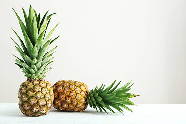 istock Ripe pineapples on a white wooden table 516851826