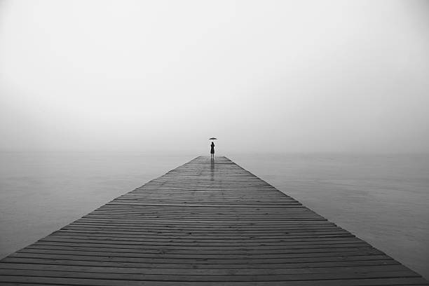 istock woman with black umbrella looking infinity in a surreal place 516852316