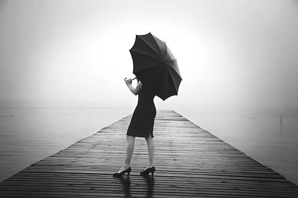 istock woman with black umbrella looking infinity in a surreal place 516853590