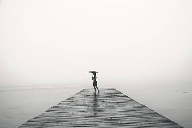 istock woman with black umbrella looking infinity in a surreal place 516855348