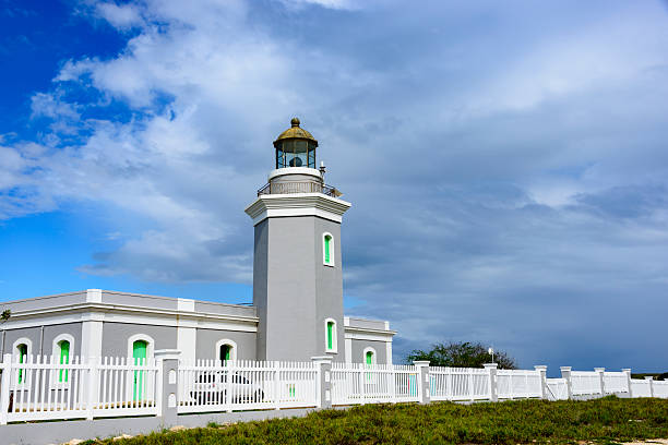 Los Morrillos lighthouse in Cabo Rojo, Puerto Rico.  The lighthouse is surrounded by a white picket fence.