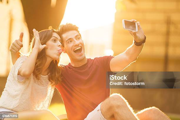 Couple Taking Silly Self Portraits On A Mobile Phone Stock Photo - Download Image Now