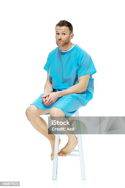 Patient Sitting On Stool Looking At Camera Stock Photo - Download Image Now - Hospital Gown, Men, Patient