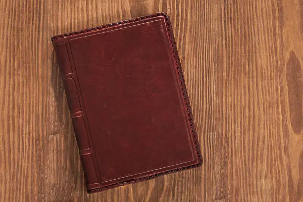 Photo of leather book on wooden board