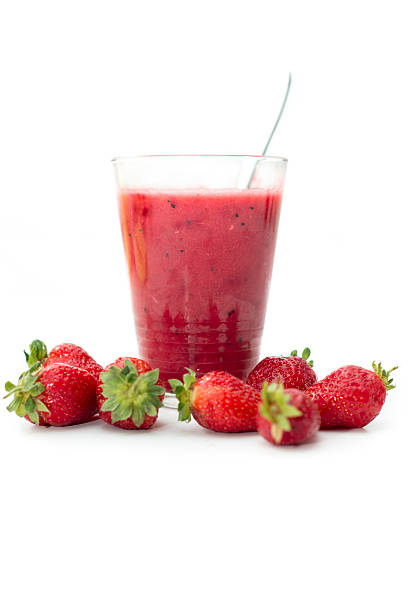 Refreshing strawberry smoothie A glass of strawberry smoothie on white background with some strawberries next to it. strawberry crush stock pictures, royalty-free photos & images