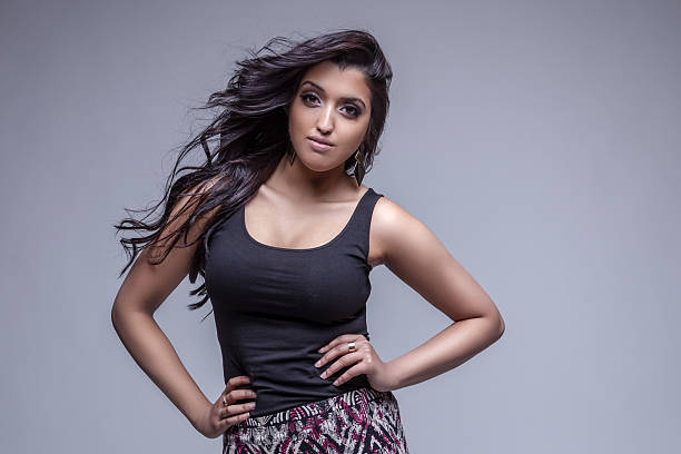 Portrait of a beautiful young woman posing against a grey background
