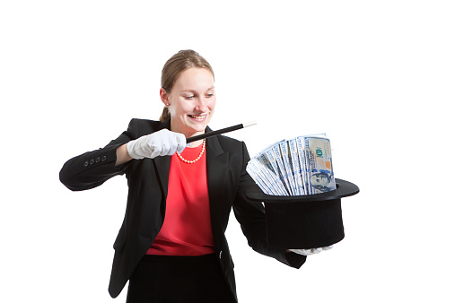 A businesswoman doing magic trick. Pulling money out of a hat. Isolated on white background