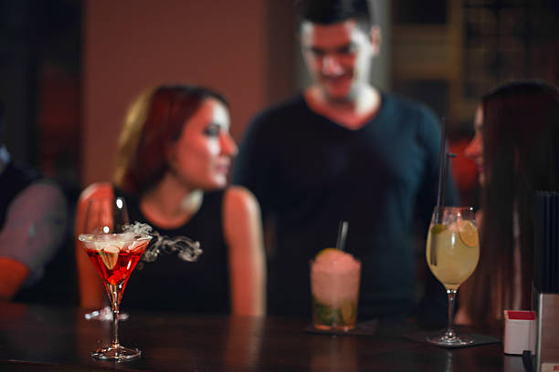 Beautiful woman dinking smoking cocktail in nightclub