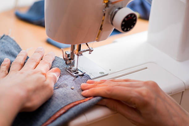 istock woman sews on the sewing machine 516889700