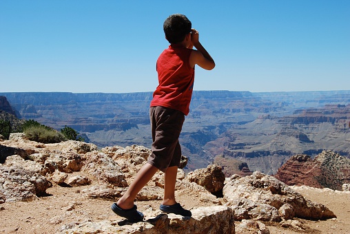Young boy admiring Grand Canyon view, whilst pretending to look through binoculars