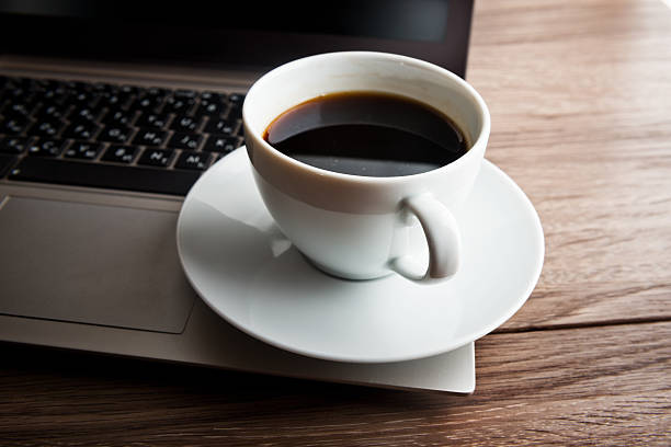 istock Cup of coffee and laptop on wooden table. 516894116