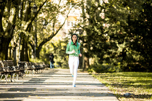 istock Young woman running in the park 516894814