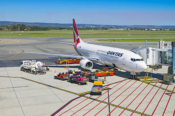 Qantas 737-800 aircraft “Coonawarra” being prepared for next flight Adelaide, Australia - March 21, 2016: The tarmac at Adelaide Airport is a hive of activity as baggage services personnel load luggage onto Qantas 737-800 aircraft “Coonawarra” as it is prepared for its next flight.  Also on the tarmac, the aircraft refueller packs up his equipment.  737 stock pictures, royalty-free photos & images