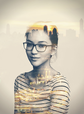 Multiple exposure portrait of a young woman superimposed over a city